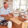 older white male and female packing kitchen boxes